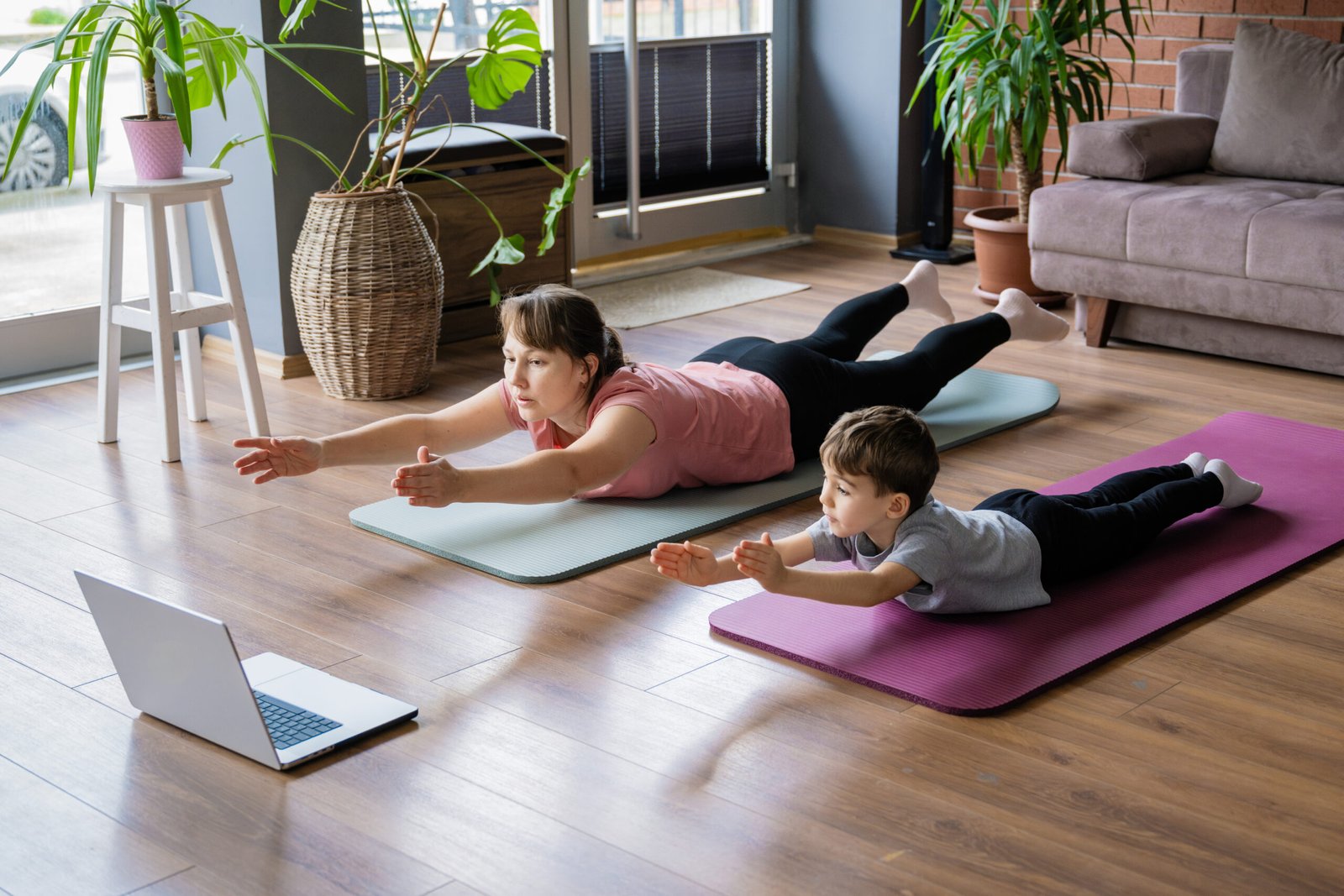 Mother and little son doing home exercises watching online tutorial